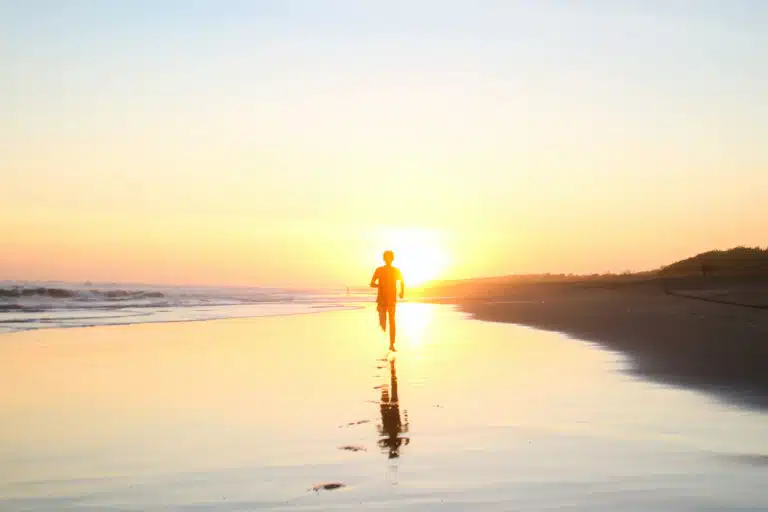 Woman running on the beach for well being