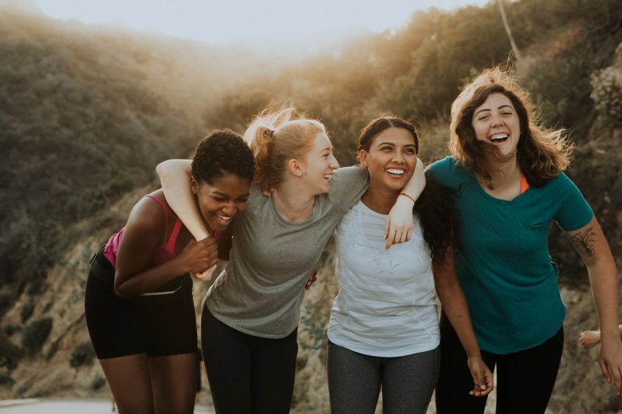 A diverse group of women representing The Aligned Entrepreneur mastermind group by Ancorio, standing together in front of a white brick wall.